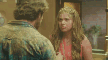 a man and a woman are looking at each other and the woman is covered in powder