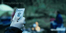 a person is holding a joker card in their hand