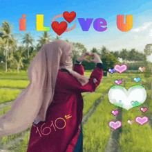 a woman in a hijab is making a heart with her hands and the words i love u