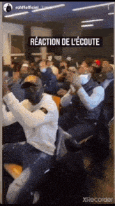 a group of people are sitting in a room with a sign that says reaction de l' ecoute .