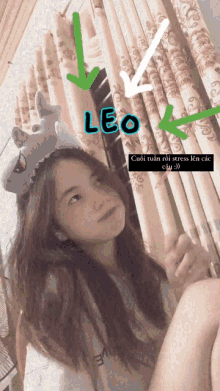 a girl wearing a headband that says leo is sitting in front of curtains
