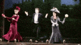 a man and two women are dancing on a stage in a theatre .
