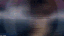 a blurred image of a person 's face with a blue light coming out of it