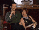 a man and a woman are sitting next to each other on a red couch