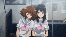 two anime girls sitting next to each other on a train