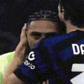 a man wearing a jersey with the number 2 on it is hugging another man .