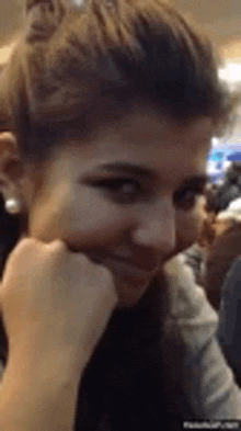 a woman is sitting at a table with her hand on her chin .