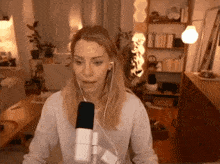 a woman wearing ear buds and a microphone in a living room