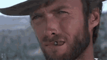 a close up of a man with a beard wearing a cowboy hat .