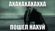a man in a suit and tie is walking across a field with the words " axaxaxaxaxxa " written in white letters