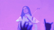 a woman is playing a guitar in front of a crowd