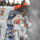 a baseball player with the number 25 on his back is being congratulated by another player