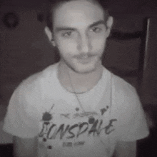a man wearing a white t-shirt with the word sonspire on it .