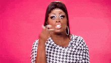 a drag queen is making a funny face and blowing a bubble .