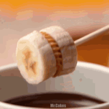 a slice of banana is being dipped in chocolate sauce