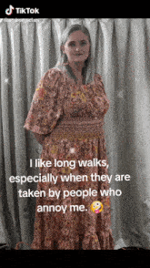 a woman in a pink and yellow dress is standing in front of a white curtain with a caption that says i like long walks