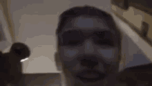 a close up of a man 's face in a dark room with a blurry background .