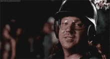 a man wearing a helmet and goggles is yawning while holding his face .