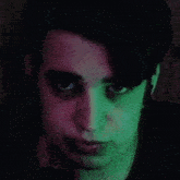 a close up of a person 's face with green and pink lights behind them