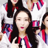 a group of young women are standing next to each other and one of them is giving a thumbs up sign .