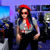 a woman wearing a red hat and sunglasses is dancing in front of a tv