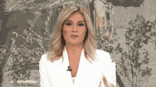 a woman in a white jacket is on a tv show called hoy noticias