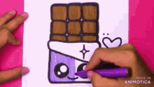 a person is drawing a chocolate bar with a face on it