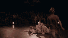 a group of people are laying on their backs on a stage
