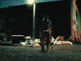a person standing in front of a pile of trash with a coca cola sign on it
