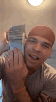 a man in a red headband is holding a stack of money in his hands