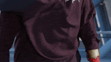 a person wearing a purple belt with a red and purple object on it