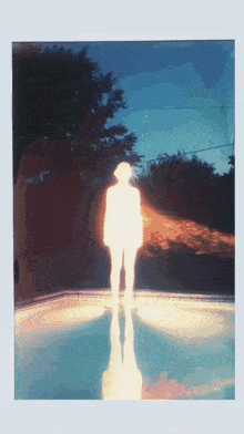 a silhouette of a person standing in front of a pool