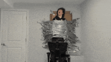 a person sitting in a chair with a cardboard box on their head
