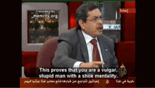 a man in a suit and tie is talking on a tv show and says this proves that you are a vulgar stupid man