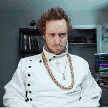 a man wearing a gold chain around his neck has a cross necklace around his neck