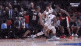 a group of basketball players are playing a game .