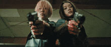 a girl with pink hair holds a gun next to another girl
