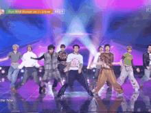 a group of young men are dancing on a stage with the words run wild on the bottom
