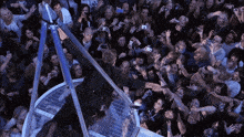 a crowd of people are gathered around a man wearing a black shirt that says ' i love you ' on it