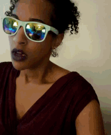 a woman wearing sunglasses has a reflection of a lamp in her sunglasses