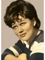 a woman wearing a blue and white striped shirt is looking at the camera
