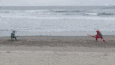 a man in a red suit is walking on the beach