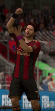 a soccer player in a red and black uniform with the number 7 on his shorts
