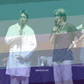 two men standing next to each other with one wearing a t-shirt that says machacattan