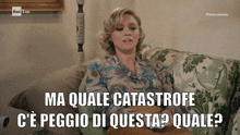 a woman sits on a couch with the words ma quale catastrofe