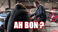 a man sitting on a stool in front of a sign that says ah bon on it