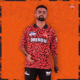 a man is wearing a red shirt that says dream11