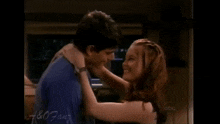 a man and a woman are kissing in front of a sign that says a & o fans