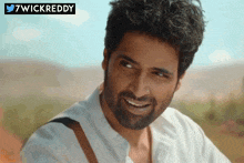 a man with a beard is smiling in front of a banner that says wickreddy