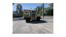 a yellow school bus is parked in a parking lot next to a building .